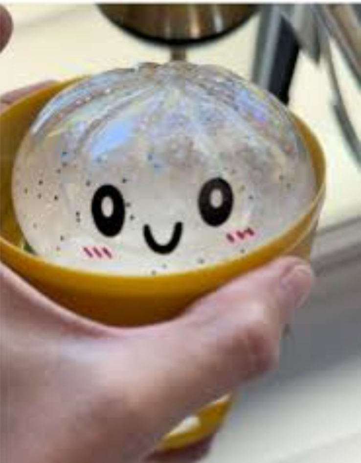 White glitter Dumpling Squishy held in one hand