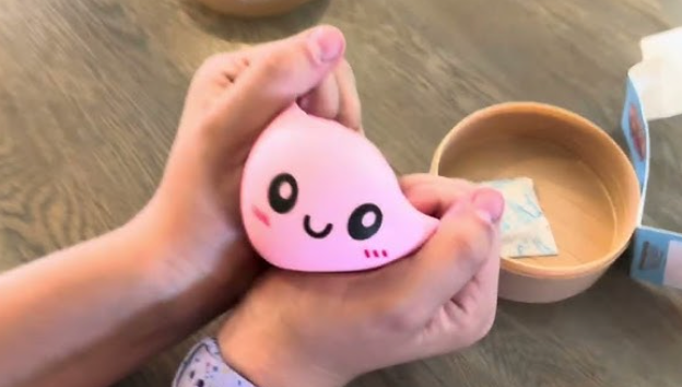 Pink Dumpling Squishy being squeezed by hand