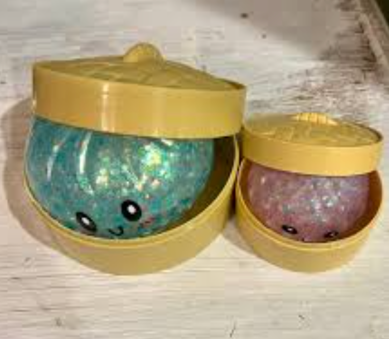 Two glitter Dumpling Squishy toys opened on a table