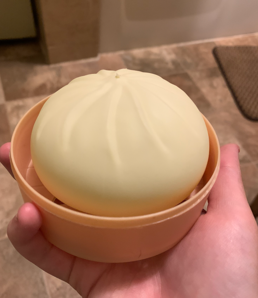Classic white Dumpling Squishy held in its steamer box