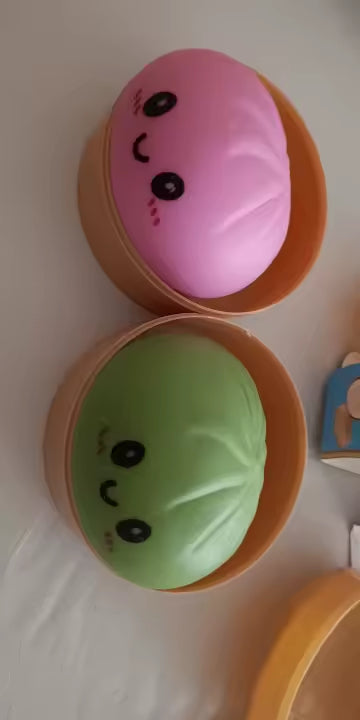 Pink and green Dumpling Squishy toys opened together