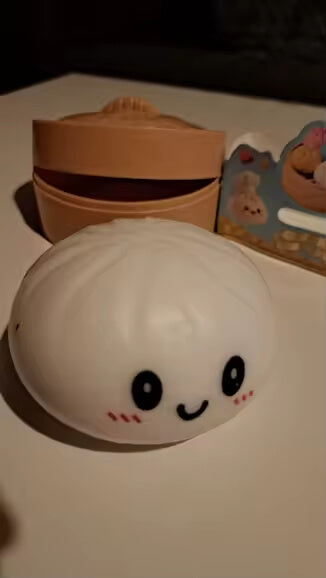 White Dumpling Squishy opened on a table in low light